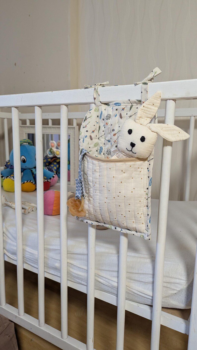 range doudou attaché à un lit