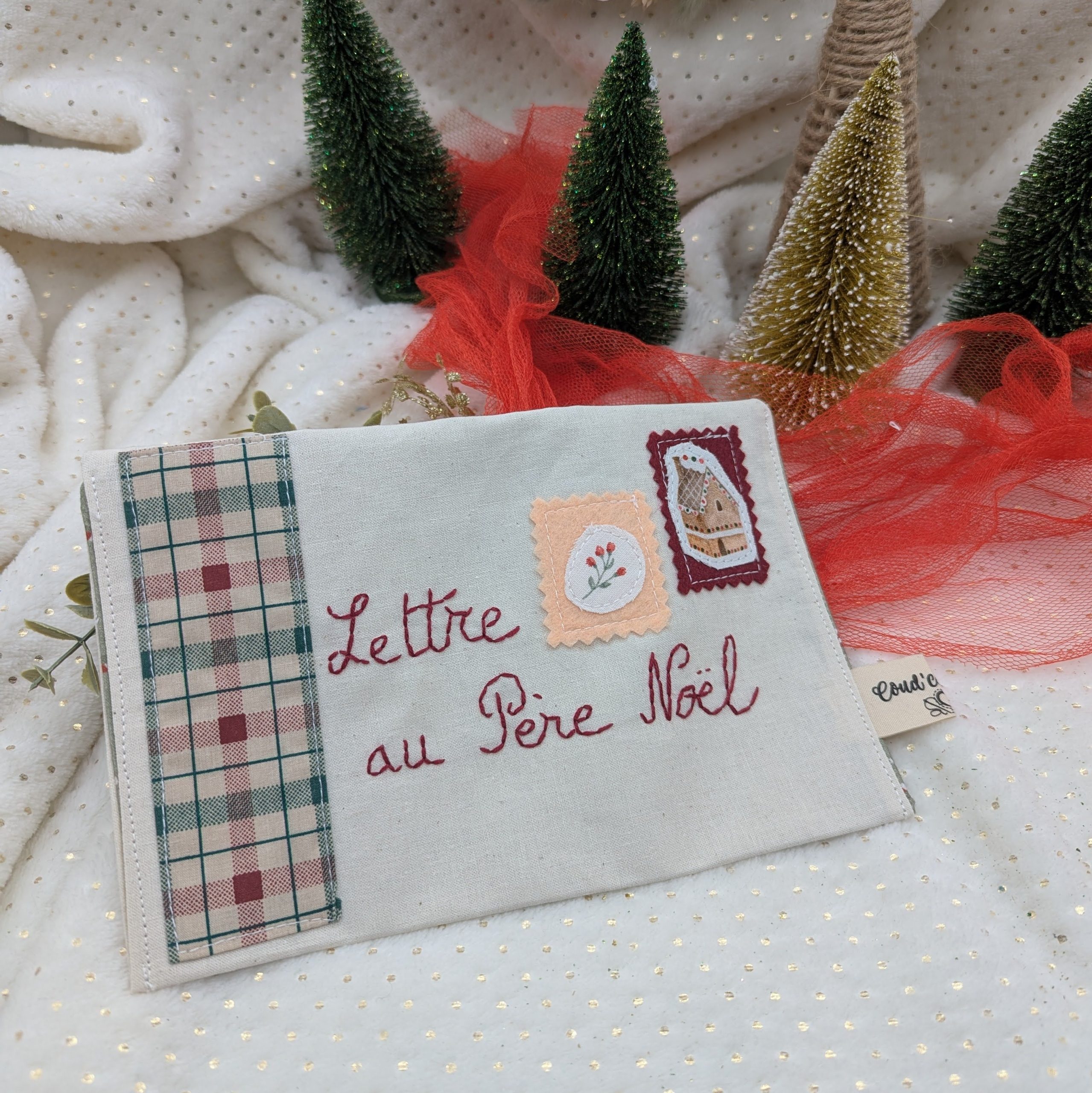 Ensemble de pochettes en tissu pour la Lettre au Père Noël fabriquées à la main par Coudcoeurcie, ornées de timbres illustrés et de finitions en tissu vichy et fleuri sur fond blanc étoilé.